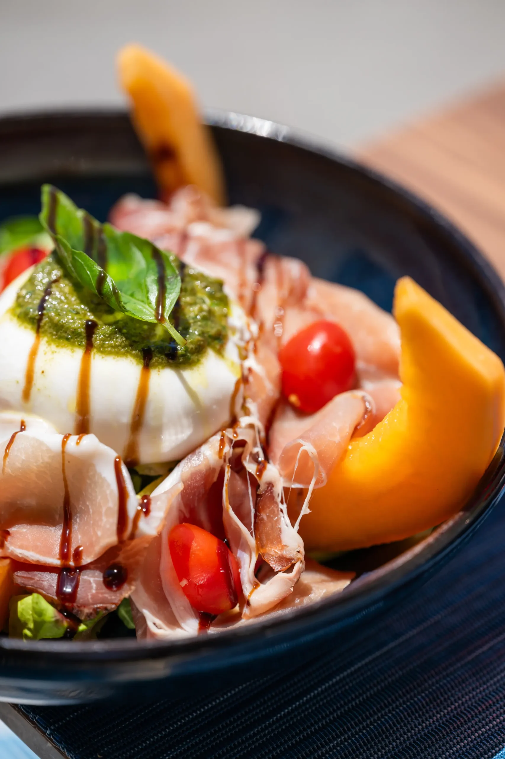 Burrata crémeuse, melon et jambon de Parme au pesto de basilic