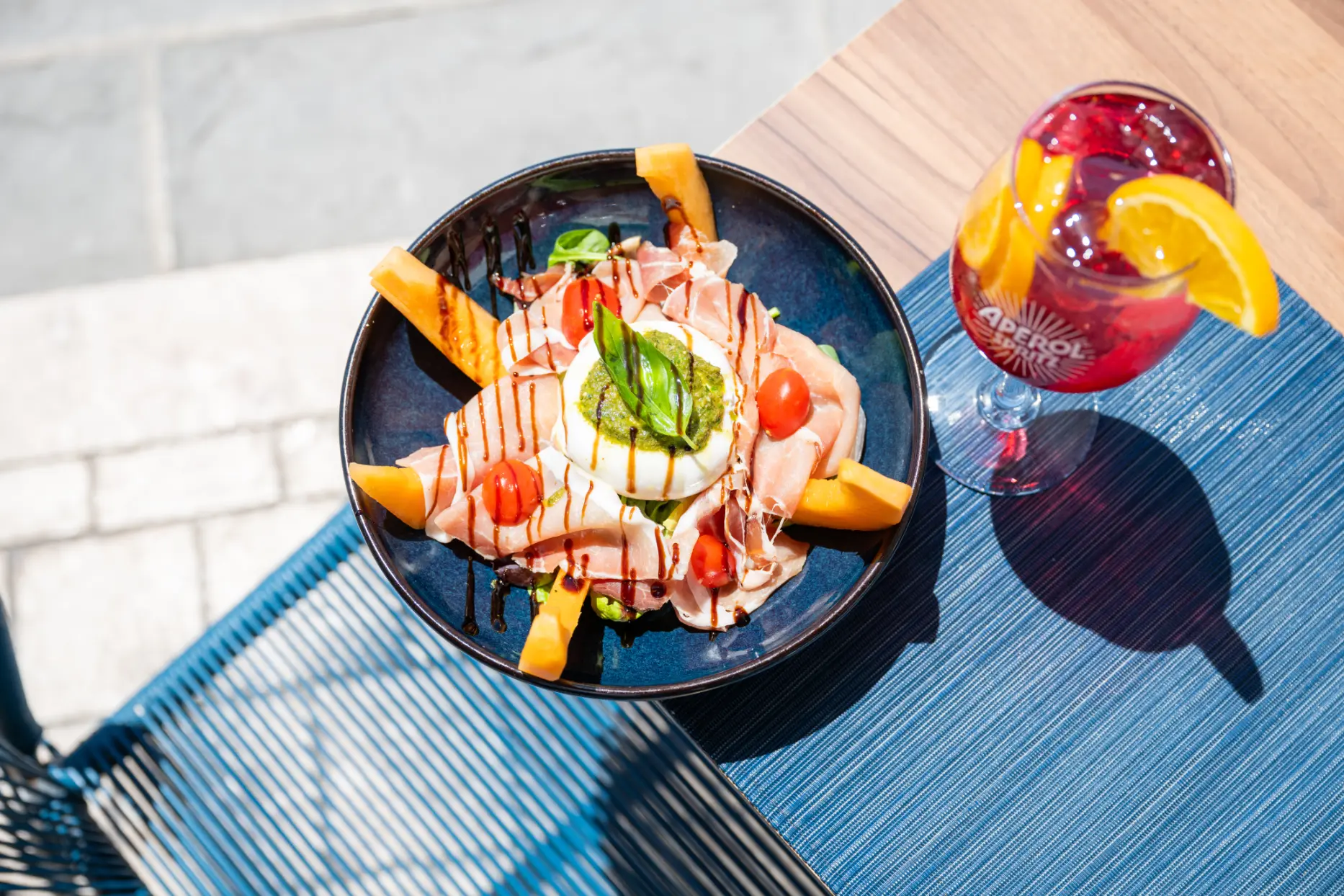 Assiette de burrata, melon et jambon de Parme accompagnée d’un spritz