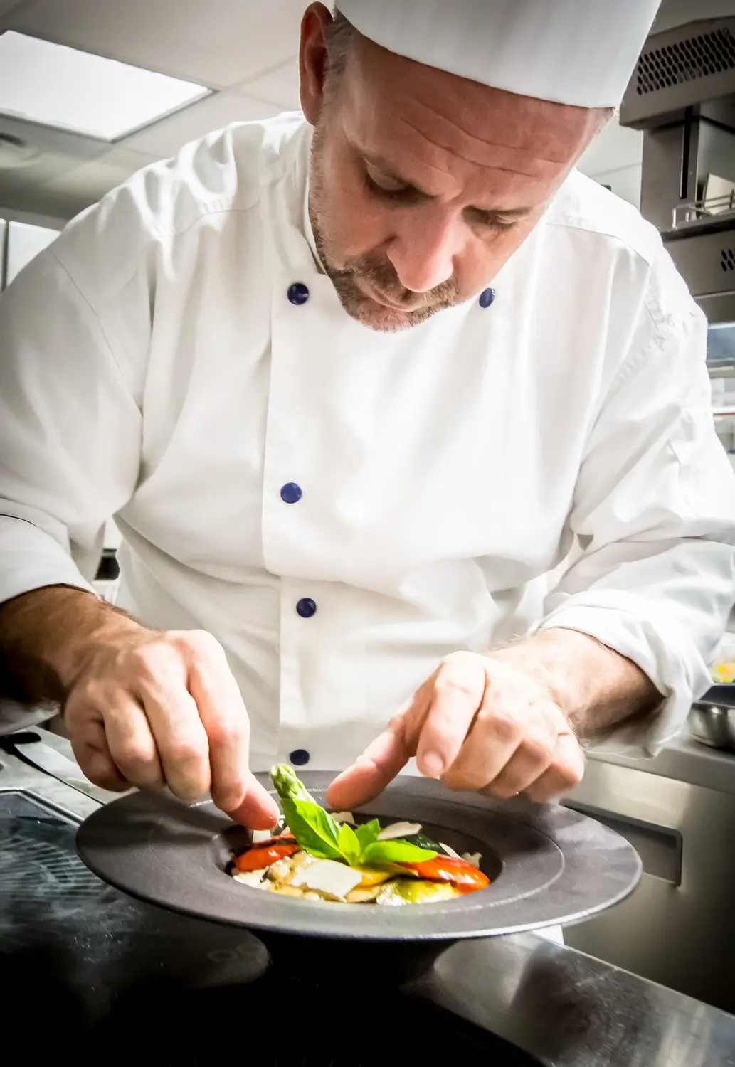 Lo chef del Casa Leya impiatta un piatto in cucina