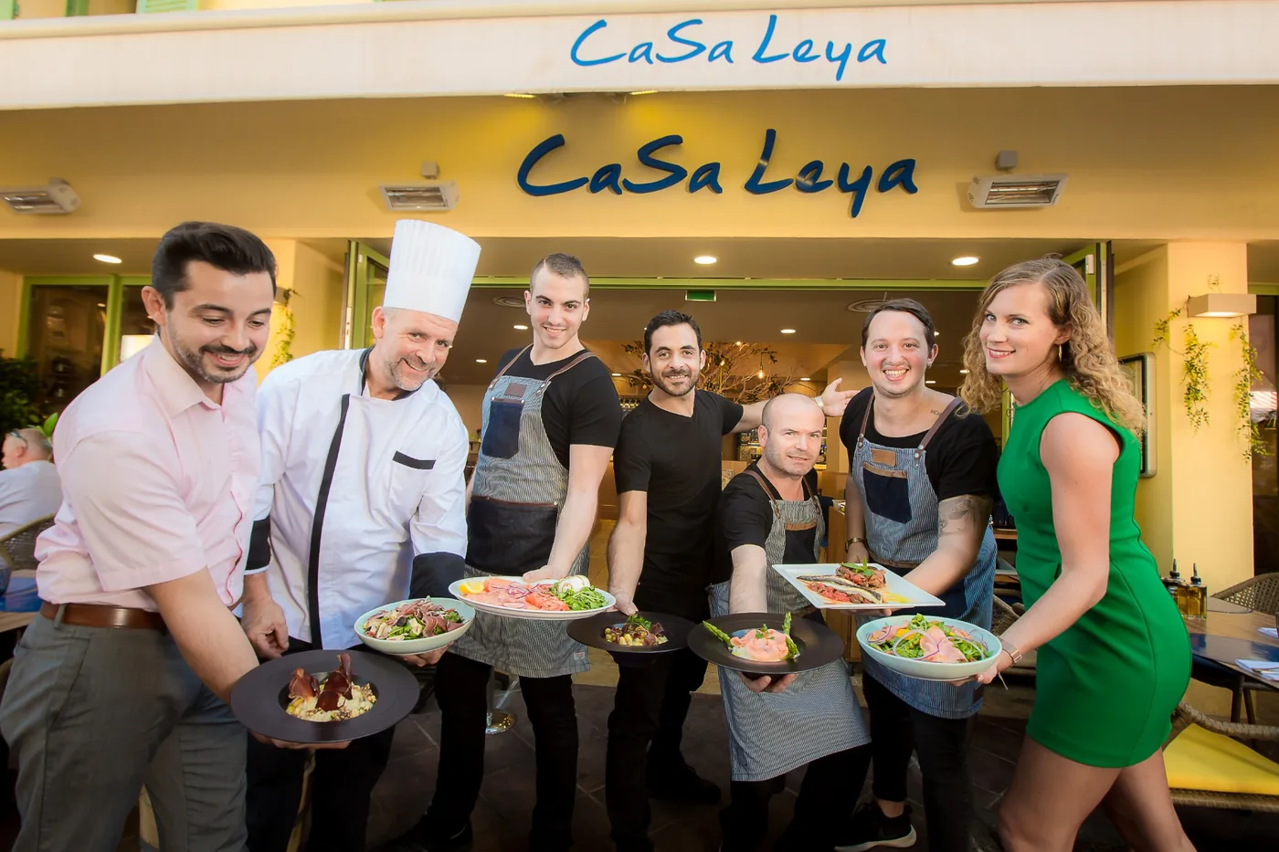 L'équipe du Casa Leya réunie devant le restaurant, plats à la main