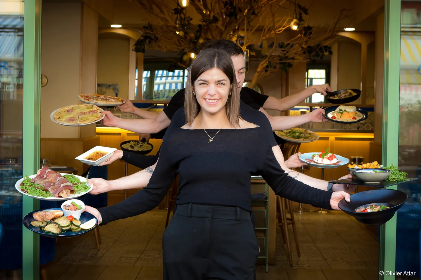 Serveuse du Casa Leya entourée des plats italiens de la carte