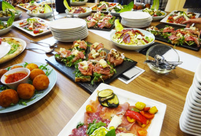 Image représentant un buffet disponible pour les groupes. Nous retrouvons des antipastis, des arancinis, des salades, des pizzas pour passer un moment convivial dans une bonne ambiance, autour d'un bon repas.