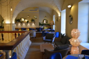 Image représentant le premier étage du restaurant qui est un lieu avec une ambiance chaleureuse, il est décoré comme le reste du restaurant avec les couleurs provençales, le jaune et le bleu. Il y a des banquettes et des chaises confortables pour garantir une bonne expérience.