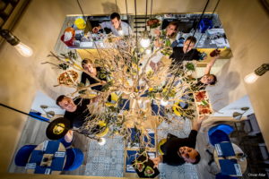 Image représentant une partie de l'équipe du restaurant. Ils se trouvent autour du citronnier de l'entrée. Ils tiennent un plat proposé par le Casa Leya dans leur main comme une pizza, des pâtes ou encore des salades.