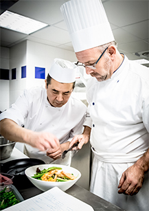 Image représentant un membre de l'équipe du Casa Leya, le chef de cuisine Dominique. Il est accompagné de son second, Mandor